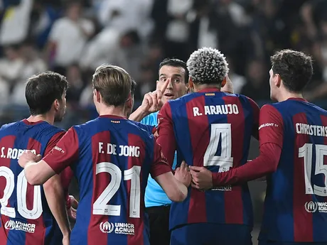 Hlavný rozhodca Juan Martinez Munuera sa rozpráva s hráčmi Barcelony, vrátane Barcelončana Ronalda Arauja, počas finálového futbalového zápasu Španielskeho superpohára medzi Realom Madrid a Barcelonou na štadióne Al-Awwal Park v Rijáde v Saudskej Arábii, v nedeľu 14. januára 2024.