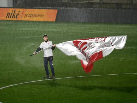 Vlajkonosič mává zástavou v hustom daždi pred začiatkom zápasu 19. kola futbalovej Niké ligy AS Trenčín – FC Košice.