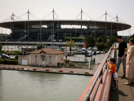 A family looks at the Canal Saint-Denis with the Stade de France stadium in background, Monday, July 10, 2023 in Saint-Denis, north of Paris. The stadium will host the athletics and para athletics and Rugby Sevens in the Paris 2024 games. (AP Photo/Thomas Padilla, File)

- OLY;stade de France;athletics