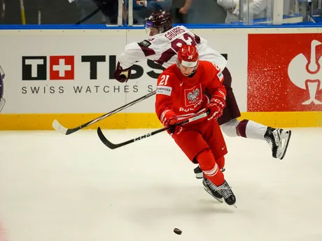 Poliak Kamil Walega a Lotyš Felikss Gavars v súboji o puk v zápase Poľsko - Lotyšsko na MS v hokeji 2024.