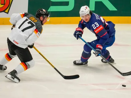 Tobias Eder a Michael Eyssimont v súboji o puk v zápase USA - Nemecko na MS v hokeji 2024.