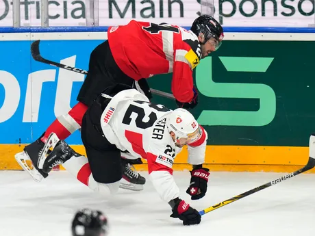 Rakúsky útočník Steven Strong v súboji so Švajčiarom Ninom Niederreiterom na MS v hokeji 2024.