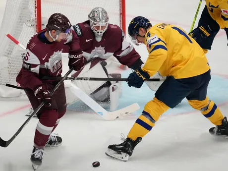 Lotyš Markuss Komuls a Švéd Joel Erikson Ek v súboji o puk v zápase Lotyšsko - Švédsko na MS v hokeji 2024.