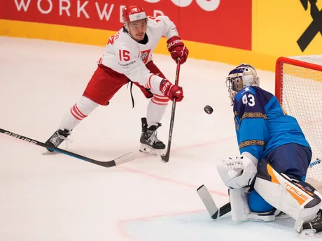 Andrey Shutov pri streleckom pokuse Patryka Wronku v zápase Kazachstan - Poľsko na MS v hokeji 2024.