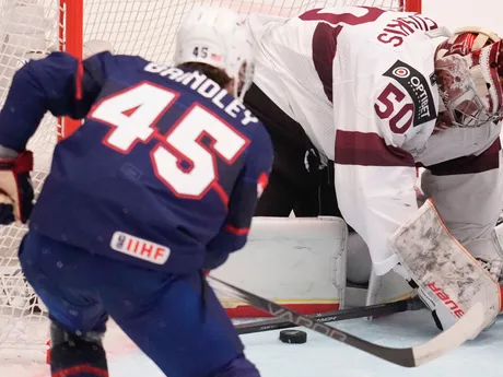 Kristers Gudlevskis a Gavin Brindley počas zápasu Lotyšsko - USA na MS v hokeji 2024.