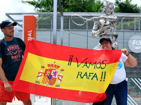 Fanúšikovia španielskeho tenistu Rafaela Nadala pózujú pred jeho sochou pred zápasom 1. kola mužskej dvojhry proti Alexandrovi Zverevovi.