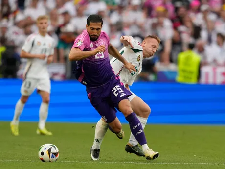 Germany's Emre Can, left, challenges for the ball with Hungary's Laszlo Kleinheisler during a Group A match between Germany and Hungary at the Euro 2024 soccer tournament in Stuttgart, Germany, Wednesday, June 19, 2024. (AP Photo/Antonio Calanni)

- XEURO2024X