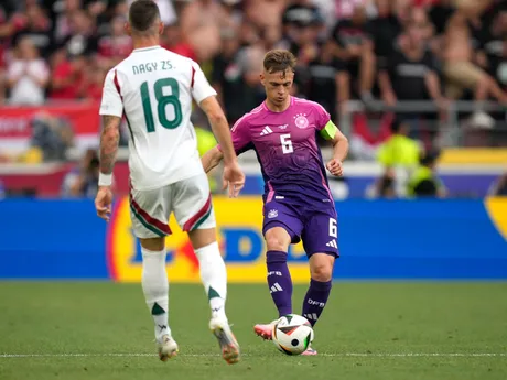 Germany's Joshua Kimmich, right, controls the ball ahead of Hungary's Zsolt Nagy during a Group A match between Germany and Hungary at the Euro 2024 soccer tournament in Stuttgart, Germany, Wednesday, June 19, 2024. (AP Photo/Ariel Schalit)

- XEURO2024X