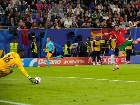 Brankár Mike Maignan zasahuje po strele Bruna Fernandesa v zápase Portugalsko - Francúzsko na EURO 2024. 