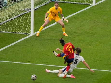 Nico Williams pri streleckom pokuse a John Stones v zápase Španielsko - Anglicko vo finále EURO 2024 (ME vo futbale).