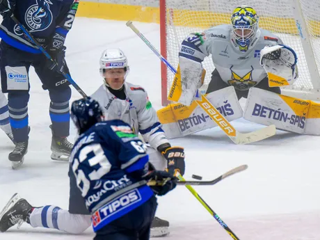 Popradský obranca Trent Bourque strieľa na lotyšského brankára Mareksa Mitensa.