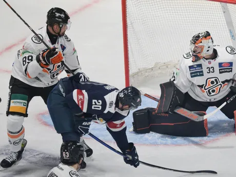 Jakub Minarík (Slovan Bratislava) v streleckom pokuse a brankár Dominik Riečický (Košice) počas zápasu 11. kola hokejovej Tipos extraligy HC Košice - HC Slovan Bratislava.