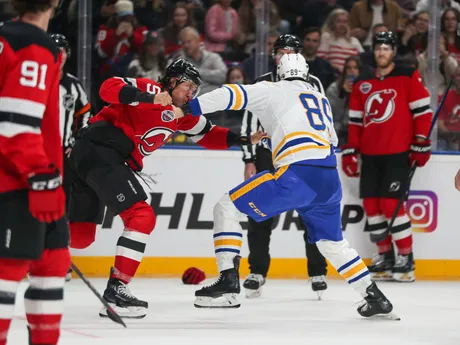 Brenden Dillon (NJ) a Alex Touch (Buffalo) v pästnom súboji  v zápase NHL New Jersey - Buffalo Sabres v Prahe.
