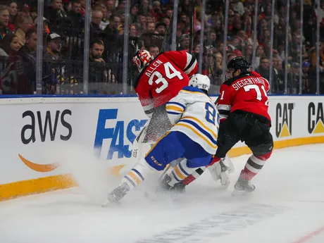 Alex Tuch (Buffalo), Jonas Siegenthaler a brankár Jake Allen (obaja New Jersey)  v zápase NHL New Jersey - Buffalo Sabres v Prahe.