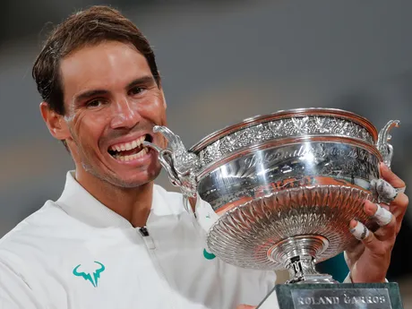 Rafael Nadal sa zahryzáva do trofeje po víťazstve nad Srbom Novakom Djjokovičom vo finále mužskej dvojhry na grandslamovom turnaji Roland Garros v Paríži 11. októbra 2020.