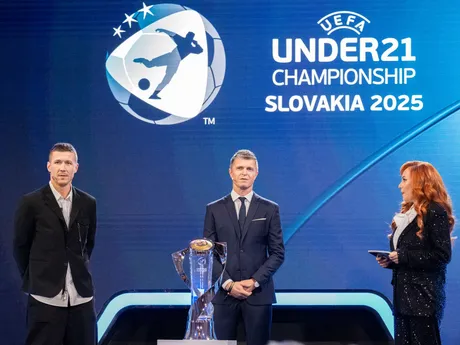 Juraj Kucka (vľavo), ambasádor turnaja Vratislav Greško a moderátorka podujatia Vera Wisterová stoja pri trofeji pre víťaza počas žrebu EURO U21 2025 v Bratislave.