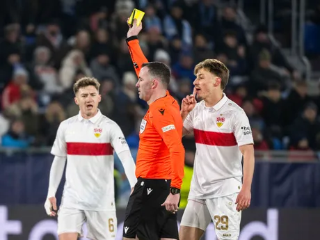 Zľava Angelo Stiller (Stuttgart), rozhodca ukazujúci žltú kartu a Anthony Rouault (Stuttgart) počas zápasu ŠK Slovan Bratislava - VfB Stuttgart v 7. kole ligovej fázy Ligy majstrov.