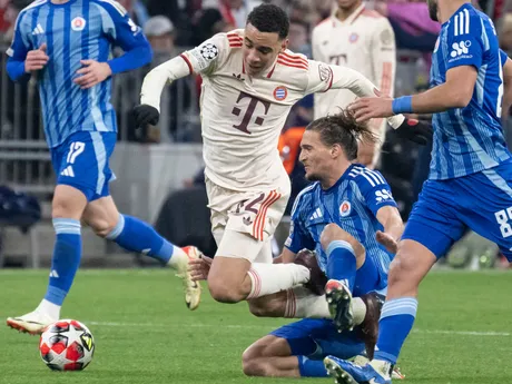 Futbalista Slovana Bratislava Július Szöke v súboji s hráčom Bayernu Jamalom Musialom. 