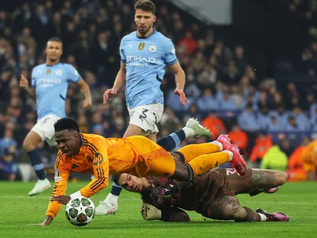 Vinicius Junior padá cez brankára Edersona v zápase Manchester City - Real Madrid v play-off o osemfinále Ligy majstrov.