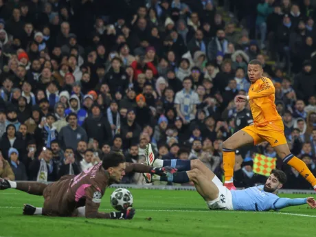 Brankár Ederson chytá strelu Kyliana Mbappého v zápase Manchester City - Real Madrid v play-off o osemfinále Ligy majstrov.