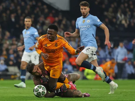 Vinicius Junior padá cez brankára Edersona v zápase Manchester City - Real Madrid v play-off o osemfinále Ligy majstrov.