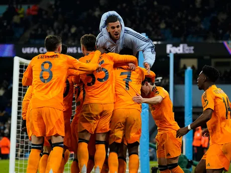 Jude Bellingham so spoluhráčmi oslavuje gól v zápase Manchester City - Real Madrid v play-off o osemfinále Ligy majstrov.