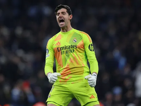 Thibaut Courtois oslavuje gól Judea Bellinghama v zápase Manchester City - Real Madrid v play-off o osemfinále Ligy majstrov.