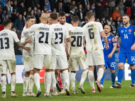 Sprava sklamaní slovenskí futbalisti Milan Škriniar, Stanislav Lobotka a radujúci sa Slovinci po výhre 1:0 v odvetnom zápase play-off o postup do B-divízie Ligy národov Slovinsko - Slovensko.