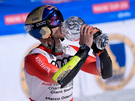 Švajčiar Marco Odermatt pózuje s malým krištáľovým glóbusom za celkové víťazstvo v obrovskom slalome Svetového pohára.