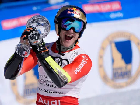 Švajčiar Marco Odermatt pózuje s malým krištáľovým glóbusom za celkové víťazstvo v obrovskom slalome Svetového pohára.