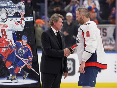 Kapitán Washingtonu Capitals Alex Ovečkin počas ceremoniálu po tom, čo strelil rekordný 895. gól v kariére. Ruský kanonier prekonal historický gólový rekord legendárneho kanadského útočníka Waynea Gretzkého, ktorý mu gratuluje.