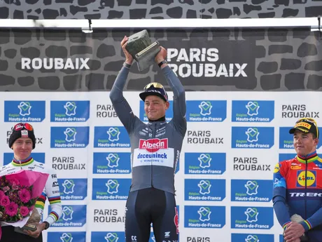 Mathieu van der Poel dvíha nad hlavu dlažobnú kocku pre víťaza Paríž - Roubaix 2025.