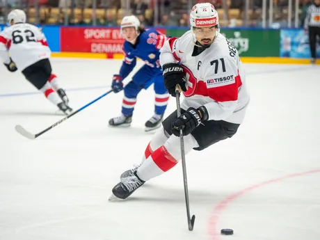 Švajčiarsky hráč Jonas Siegenthaler (vpravo) bojuje o puk s Američanom Loganom Cooleyom v zápase B-skupiny USA - Švajčiarsko na MS 2025.
