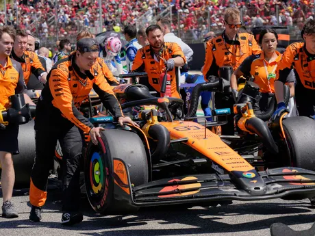 Technici tlačia monospost austrálskeho pretekára Oscara Piastriho z tímu McLaren do štartovacieho boxu pred začiatkom pretekov VC Emilia Romagna.