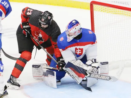 Michal Prádel zasahuje proti Tylerovi Hopkinsovi v zápase Slovensko - Kanada  v semifinále MS 18 v hokeji.
