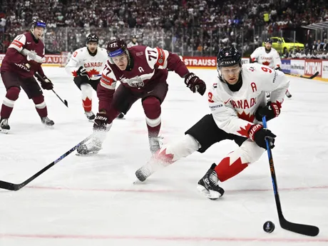 Nathan MacKinnon (vpravo) a Kristaps Roberts Zile v zápase Lotyšsko - Kanada na MS v hokeji 2025. 
