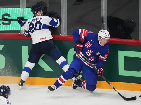 Hokejista USA Jackson LaCombe (2) a Fín Eeli Tolvanen (20) v zápase štvrťfinále USA - Fínsko na MS v hokeji 2025.