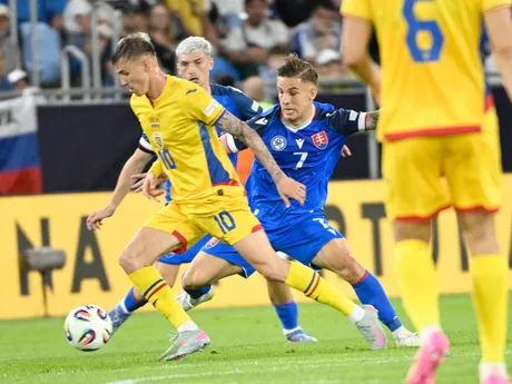vľavo George-Octavian Popescu (Rumunsko) a vpravo Tomáš Suslov (Slovensko)  bojujú o loptu počas zápasu základnej A-skupiny Rumunsko - Slovensko na majstrovstvách Európy futbalistov do 21 rokov v Bratislave