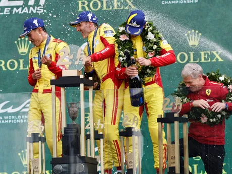 posádka víťazného vozidla Ferrari s číslom 83 v zložení Robert Kubica (uprostred), I-fej Jie (uprostred vľavo) a Phil Hanson sa teší na pódiu