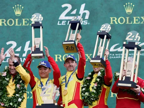posádka víťazného vozidla Ferrari s číslom 83 v zložení Robert Kubica (uprostred), I-fej Jie (uprostred vľavo) a Phil Hanson sa teší na pódiu