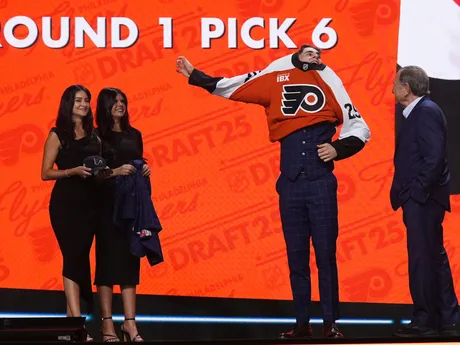 Porter Martone (druhý sprava) si oblieka dres vedľa komisára NHL Garyho Bettmana (vpravo) po tom, ako si ho v piatkovom drafte NHL 27. júna 2025 v Los Angeles vybral tím Philadelphia Flyers.