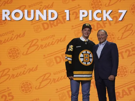 James Hagens (vľavo) stojí s komisárom NHL Garym Bettmanom po tom, ako si ho v piatkovom drafte NHL 27. júna 2025 v Los Angeles vybral tím Boston Bruins. 