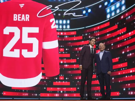 Carter Bear (vľavo) stojí s komisárom NHL Garym Bettmanom po tom, ako si ho v piatkovom drafte NHL 27. júna 2025 v Los Angeles vybral tím Detroit Red Wings.