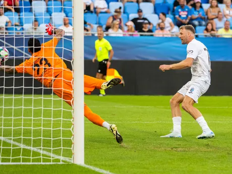 Na snímke zľava brankár Ugurcan Cakir a Adam Nemec dáva gól počas rozlúčkového zápasu s Marekom Hamšíkom na Národnom futbalovom štadióne 5. júla 2025 v Bratislave.