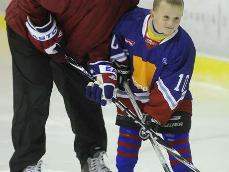 Slovenský hokejista Marián Gáborík (vľavo) pózuje s mladým hokejistom počas tréningu so žiakmi hokejovej školy.