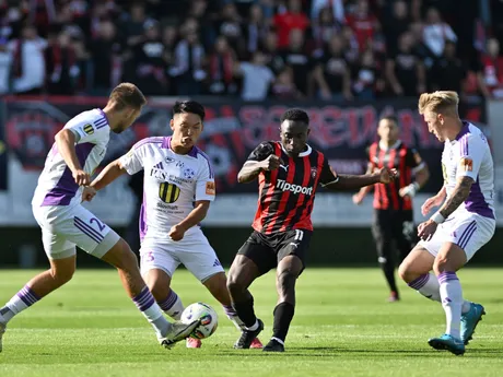Futbalista Spartaka Trnava Philip Azango v obkľúčení troch hráčov Komárna. 