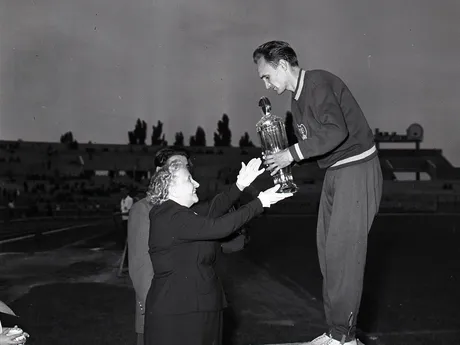 Dušan Čikel preberá z rúk vdovy po Jánovi Hajdócym veľký brúsený pohár za víťazstvom v pretekoch na 1500 m na prvom ročníku atletického mítingu Cena Pravdy v roku 1957. Hlavná disciplína mítingu niesla názov Memoriál Jána Hajdócyho po známom trénerovi, pedagógovi a veľkom propagátorovi atletiky. 
