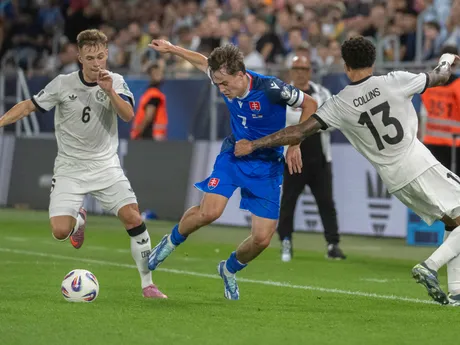 Uprostred hráč Slovenska Leo Sauer, vľavo hráč Nemecka Joshua Kimich a vpravo hráč Nemecka Nnamdi Collins v úvodnom kvalifikačnom zápase na MS 2026 A-skupiny Slovensko - Nemecko