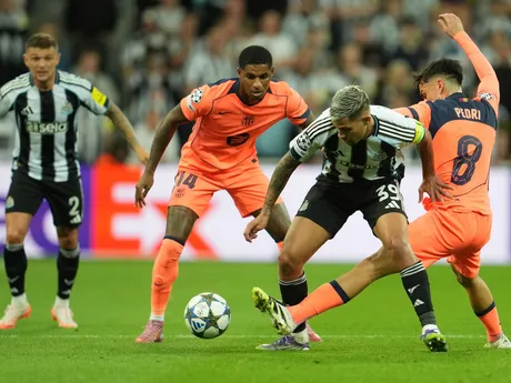 Bruno Guimaraes v súboji s Pedrim a Marcusom Rashfordom v zápase Newcastle United - FC Barcelona