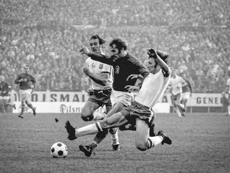 Zdeněk Nehoda v súboji s dvojicou Paul Madeley a Colin Todd v zápase kvalifikácie ME 1976 Československo - Anglicko (2:1) 30. októbra 1975  v Bratislave.